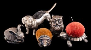 Five novelty metal pin cushions: in the form of an owl, turtle, hedgehog, hare and a dachshund (5).
