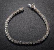 An 18ct white gold and 8ct diamond line tennis bracelet: with forty-eight circular brilliant-cut