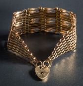 A 9ct gold ten bar, gate-link bracelet: with heart-shaped padlock clasp and safety chain,