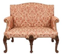 An 18th Century and later carved walnut settee:, with an arched upholstered stuff over back,