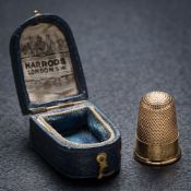 A Victorian gold thimble 'Xmas 1891' in Harrods case: the thimble without holes and in good