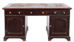 An Edwardian mahogany pedestal desk:, the rectangular top with a moulded edge,