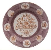 A mid 18th century delftware deep plate: painted in iron-red with a basket of flowers,