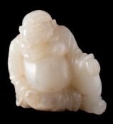 A Chinese jade carving of Budai: the stone of pale celadon colour with white and russet inclusions