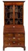 A George III mahogany bureau bookcase:, the later upper part with a moulded dentil cornice,