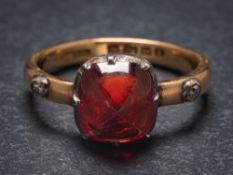A red spinel and diamond mounted three-stone ring: the rectangular red spinel within a silver