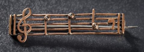 A rose diamond-set 'music' bar brooch: approximately 44mm long overall.