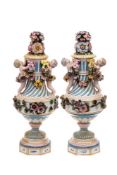 A pair of Dresden neo-classical urns and covers: each of spiral fluted form applied with putti and