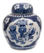 A Chinese blue and white ginger jar and cover: painted with two foliate panels of auspicious