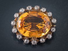 A topaz and diamond oval brooch: the oval topaz approximately 20mm long x 16mm wide x 8.
