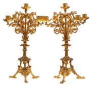 A pair of late Victorian gilt metal four-branch candelabra: with plain cylindrical nozzles on swept