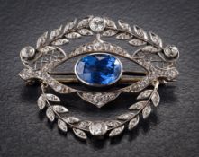 A sapphire and diamond brooch: with central shaped oval sapphire approximately 11mm long x 7.