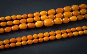 A graduated amber bead three-string necklace: with oblong beads graduated from approximately 9mm to