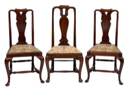 A set of four George II mahogany dining chairs: the curved backs with shaped toprails and pierced