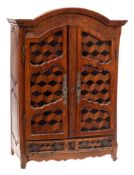 A miniature armoire: with arched moulded cornice and incised frieze,