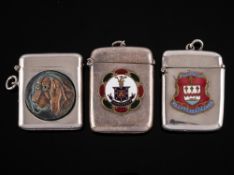 Two silver plated vesta cases: of rectangular outline bearing enamel coats-of-arms and another