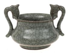 A Chinese Guan type two-handled bowl: of bombe form with dragon head handles,