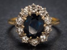A sapphire and diamond oval cluster ring: the central oval sapphire approximately 10mm long x 8mm