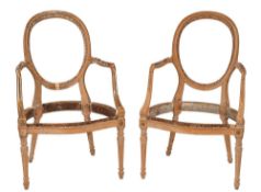 A matched pair of Louis XVI carved beechwood fauteuil frames:, with oval backs,