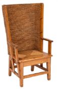 An Orkney Islands pine wing armchair:, with a curved ropework back and slip in seat,