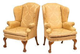 A pair of carved beechwood wing frame armchairs:, in the early 18th Century taste,