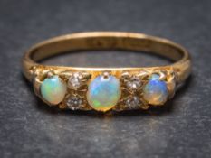 An 18ct gold, opal and diamond seven-stone ring: Chester assay marks to shank, ring size K 1/2.