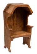 A child's 19th Century pine settle:, with a canted overhanging canopy, shaped arms and solid seat,
