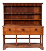 A 19th Century oak dresser:, the shelved superstructure with a moulded cornice,