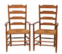 Cotswold School - A pair of oak Clissett ladder back armchairs in the manner of Edward Gardiner: