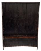 A 19th Century stained pine curved settle:, the high plank back with concave top rail,
