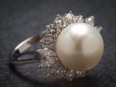 An 18ct white gold cultured pearl and diamond cluster ring: the central cultured pearl