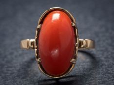 A 9ct gold and oval coral single-stone ring: the oval coral approximately 17mm long x 9mm wide
