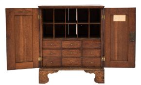 An early 19th Century oak table stationery cabinet:, with a reeded cornice,