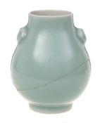 A small Chinese celadon vase: of pear shape with mask head handles and on cylindrical foot,