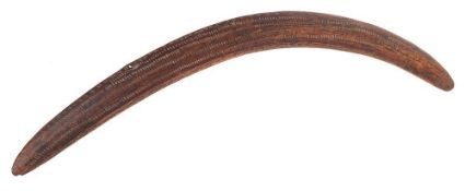 A late 19th century Aboriginal boomerang: of traditional design with incised decoration to one side,