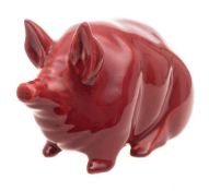 A Robert Heron & Sons Wemyss Ware pottery pig: modelled seated under a burgundy glaze,