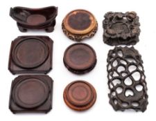 A collection of eight Chinese carved hardwood and other stands: including a graduated pair of
