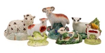 A group of six pearlware and other earthenware models of sheep: three standing,