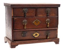 An antique miniature oak chest: of rectangular outline containing two short and two long drawers on