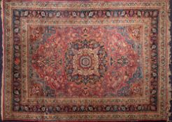 A Meshed carpet:, the shaded wine cartouche field with a central indigo pole medallion,