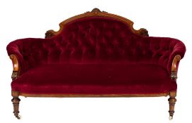 A Victorian carved walnut and inlaid settee:, of curved outline,
