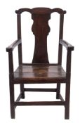 An 18th Century oak open armchair:, the back with shaped toprail and solid vase shaped splat,
