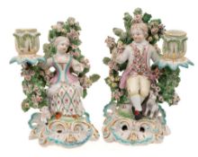 A pair of Derby figural candlesticks: in the form of a seated boy and girl,