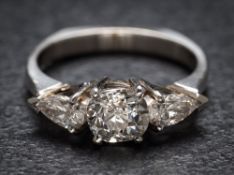A platinum and diamond three-stone ring: with central cushion-shaped old brilliant-cut diamond