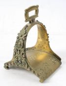 An 18th century brass stirrup: with cast foliate decoration, 18cm high.