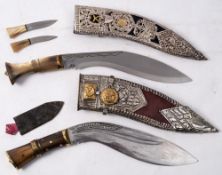 Two horn handled kukri knives: both in pressed steel decorated scabbards (2)