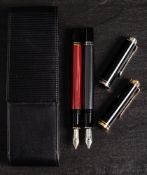 Two Pelikan M400 Souveran fountain pens: one in red, the other in grey, in a leather case.