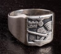 A WWII German battery Defence ring: of silver colour with emblem and text over a gun emplacement.