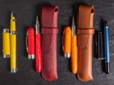 Two Viscoti Rembrandt rollerball pens: one red the other orange,