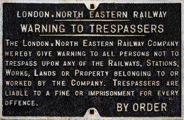 A LNER cast iron trespass penalty notice: white raised text with border, 43 x 66cm.